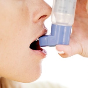 Woman Using an Inhaler --- Image by © Royalty-Free/Corbis
