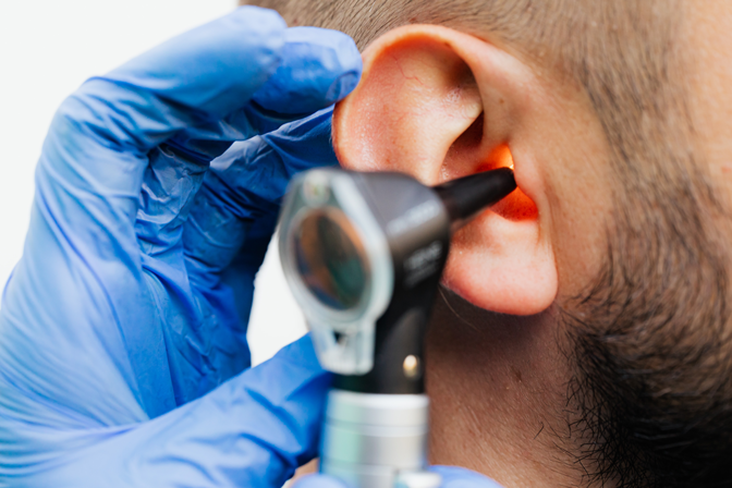 A imagem mostra o exame auditivo. O médio especialista usa de ferramentas para verificar a saúde auditiva no paciente.