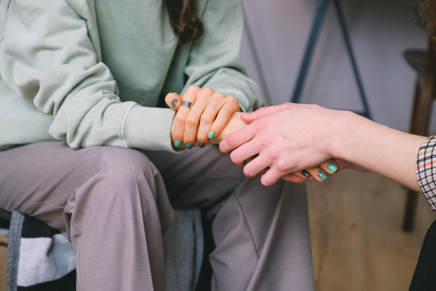 Psicóloga segura a mão da paciente durante a sessão de terapia.